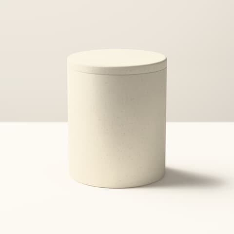 A matte sand-coloured cylindrical vessel with a flat lid, in bright midday light